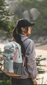Outdoor hiking backpack with grey and pink panels and mountain logo on a hiker