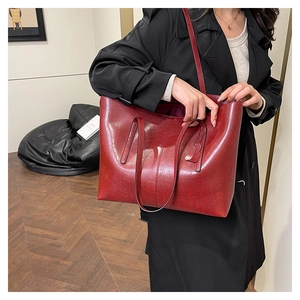 Detail of spacious dark red leather tote bag showing smooth texture and interior lining