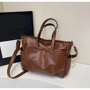 Gros plan du cabas marron avec texture grainée, poche latérale et bandoulière réglable