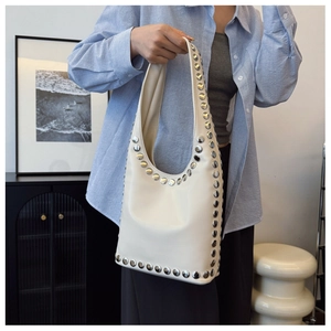 Detailansicht der cremefarbenen Hobo-Tasche mit silbernen Nieten und Lederstruktur