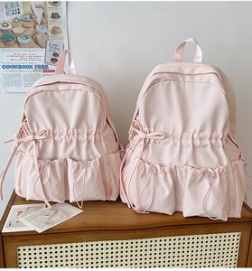 Detail of pink school backpack with bow decoration and durable nylon fabric texture