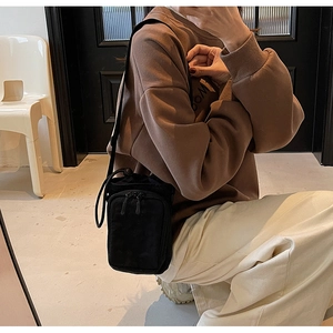 Vue verticale d'un sac bandoulière en toile noire avec fermeture à cordon serrage