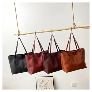 Detail view of large tote bags in four retro colors hanging on a wooden pole