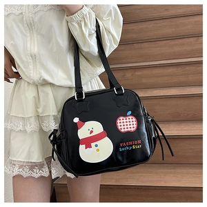 Detail of cute snowman and apple print on black PU leather tote bag with shoulder strap