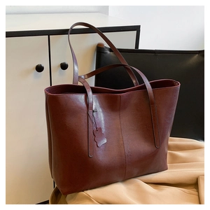 Detailed close-up of dark wine red tote bag with premium leather texture and stitching