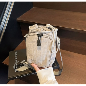 Détail du sac à bouteille d'eau en nylon beige avec cordon de serrage et zips
