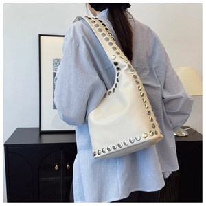 Detailansicht cremefarbene Hobo-Tasche mit silbernen Metallnieten und breitem Schultergurt