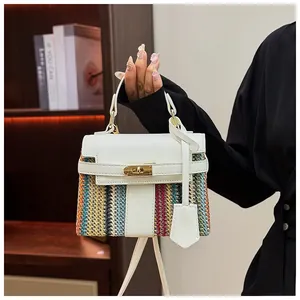 Dettaglio di una borsa a mano intrecciata stile Kelly con strisce colorate e pelle bianca