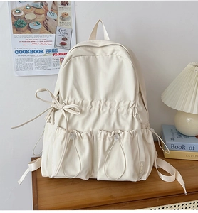 Detail of cream white school backpack with ribbon drawstrings and waterproof fabric