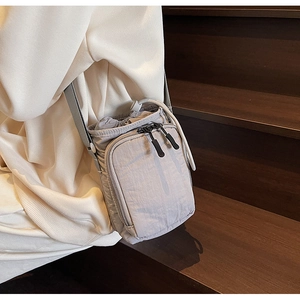 Détail d'un sac bandoulière en nylon gris imperméable avec cordon et sangle ajustable