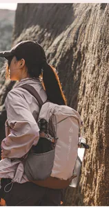 Close-up of beige outdoor backpack showing anti-tear grid fabric and side buckles
