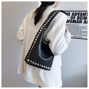 Detail der schwarzen Hobo-Tasche aus Leder mit großen Silbernieten am Schultergurt