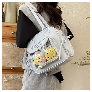 Detailed side view of white PU leather Ita bag with clear window and plush charms