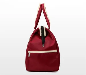Side view of a large burgundy travel bag showing durable fabric and side zipper pocket