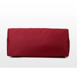 Detailed bottom view of the burgundy travel bag showing durable fabric and precise stitching