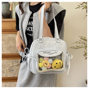 Close-up of white PU leather tote featuring clear front pocket with colorful plush flowers