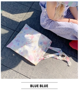 Dettaglio della borsa tote in tessuto a fiori colorati con etichetta del marchio