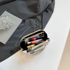 Silver mirror metal clutch bag with chain handle showing inner capacity for cosmetics