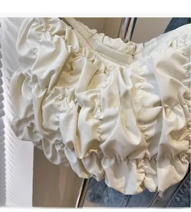 Dettaglio della borsa a nuvola bianco crema con trama in nylon plissettato e cerniera