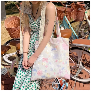 Foto all'aperto di una borsa shopper floreale con stampa macaron colorata e tracolla comoda