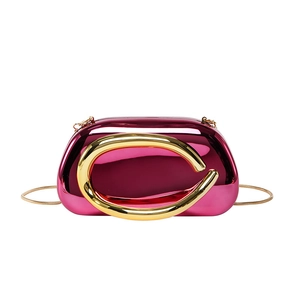 Modern magenta acrylic clutch bag with a large gold C-handle and fine snake chain strap