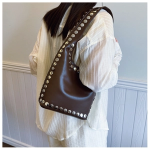 Detail der dunkelbraunen Leder-Schultertasche mit Vintage-Silbernieten an Gurt und Korpus