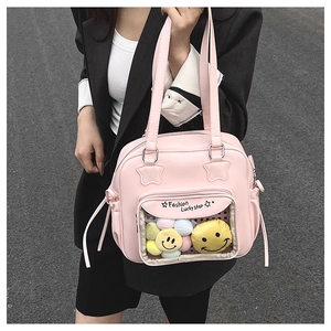 Detail of pink tote bag with transparent pocket containing colorful plush smile faces