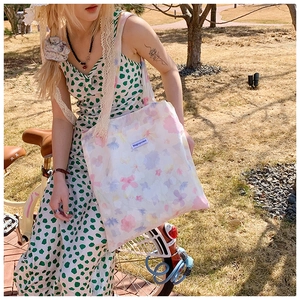Borsa tote floreale Magicpocket mostrata in una scena di vita all'aperto in bici