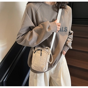Détail de la texture d'un mini sac bandoulière en toile beige avec fermeture à cordon serré