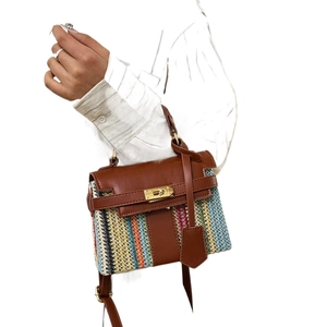 Borsa a mano tessuta a righe colorate con patta in pelle marrone e chiusura dorata