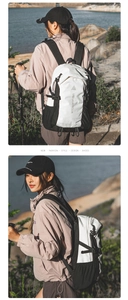 Close-up of black and white outdoor backpack with mesh side pockets and hiking poles