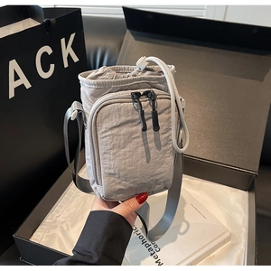 Détail du sac bandoulière en nylon gris pour gourde avec cordon et poches zippées
