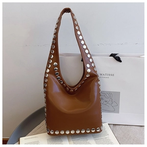 Detail of a brown leather hobo bag featuring large silver metal rivets and soft texture