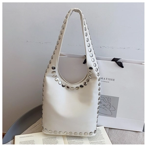 Close-up of beige leather shoulder bag with vintage silver rivet details and hobo style