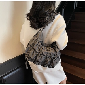 Dettaglio della borsa a tracolla grigio scuro con texture increspata e stile moderno