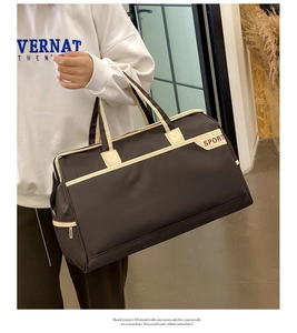 Detail view of large dark brown sport travel bag with cream trim and dual handles