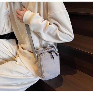 Détail d'un sac bandoulière en nylon gris imperméable avec sangle réglable
