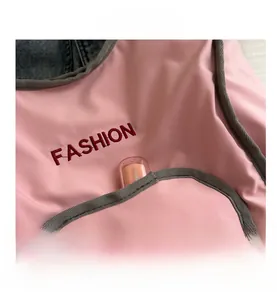Détail du sac à dos rose avec broderie FASHION et poche avant pratique et élégante