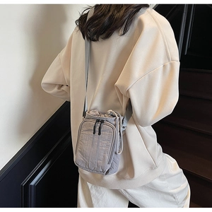 Détail d'un sac porte-bouteille en nylon mauve avec fermeture à cordon et sangle réglable