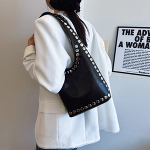 Vintage black leather tote bag with silver metal studs shown from a side view on model