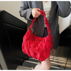 Dettaglio della borsa a nuvola rossa increspata con texture soffice e tracolla