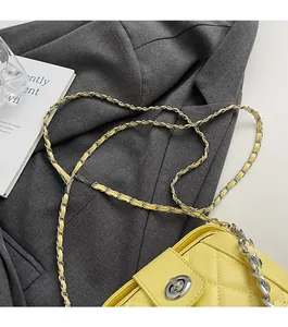 Dettaglio della borsa in pelle trapuntata gialla con catena argento e chiusura a scatto