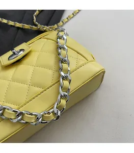 Dettaglio borsa in pelle trapuntata gialla con catena argento e chiusura a girello