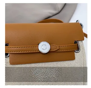 Detail of crossbody bag showing leather and woven fabric texture with silver buckle