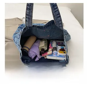 Macro view of large capacity blue denim tote bag inner space with daily essentials