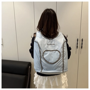 Détail du gilet matelassé bleu clair avec poche en forme de cœur et imprimé mode