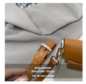 Detail of adjustable strap and silver metal buckle on color-block canvas shoulder bag