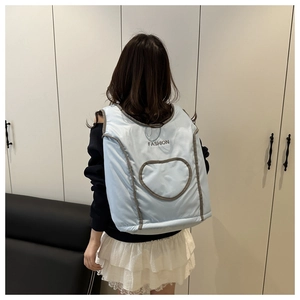 Détail du sac à dos bleu clair matelassé style gilet avec motifs cœur et logo