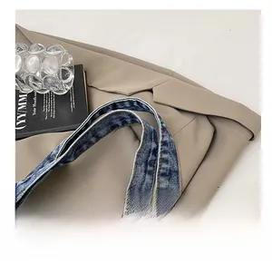 Detail of blue denim tote bag shoulder strap with durable white double stitching reinforcement