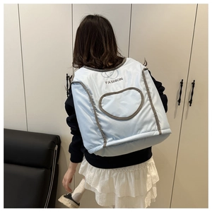 Détail du gilet matelassé bleu clair avec texte FASHION noir et motif de cœur